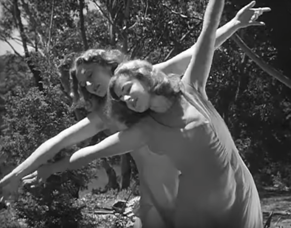 Black and white photo of two dancers in a garden.