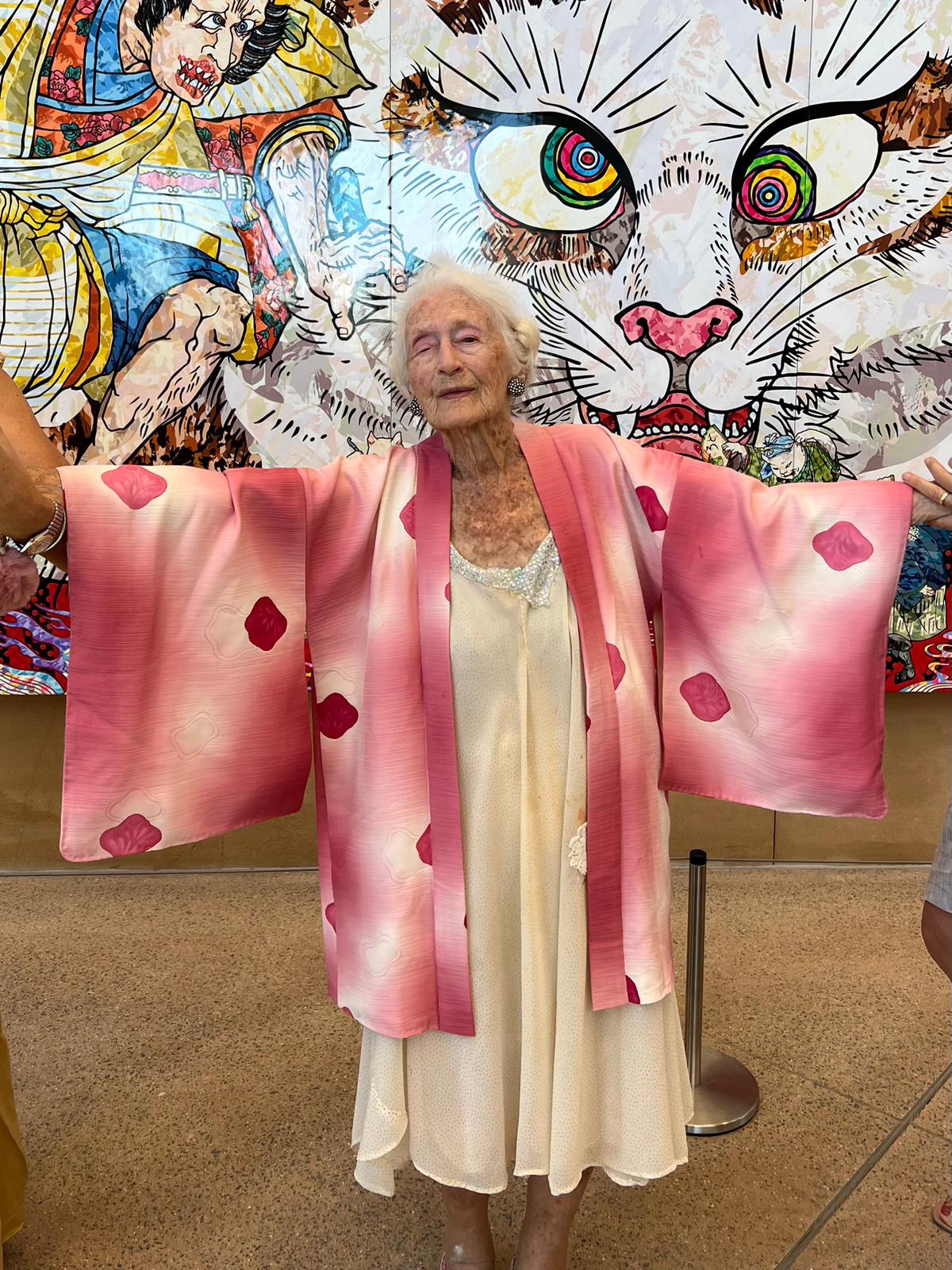 Eileen Kramer posing in a pink kimono with arms outstretched
