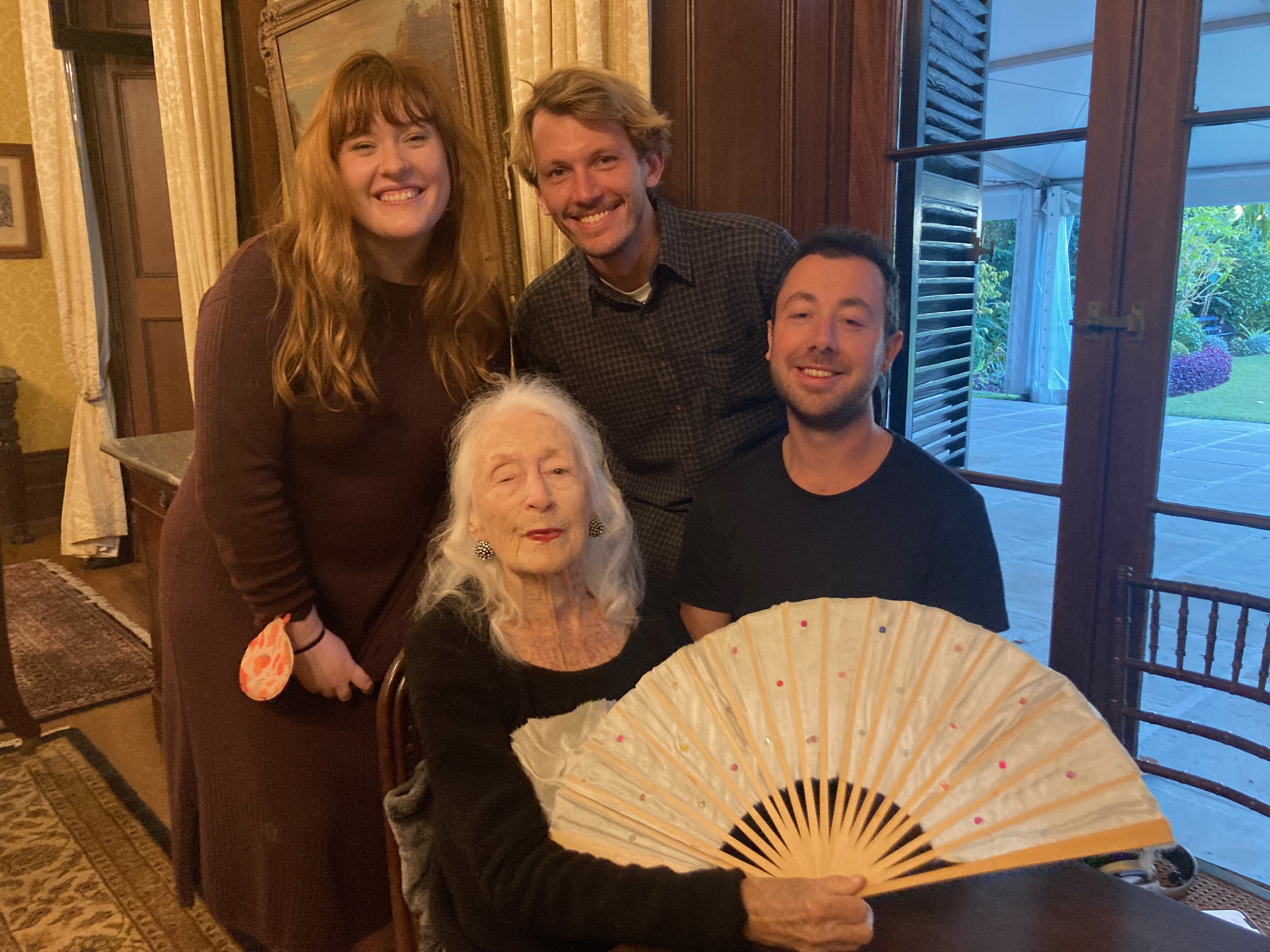 Eileen holding a fan, with the crew after filming an interview